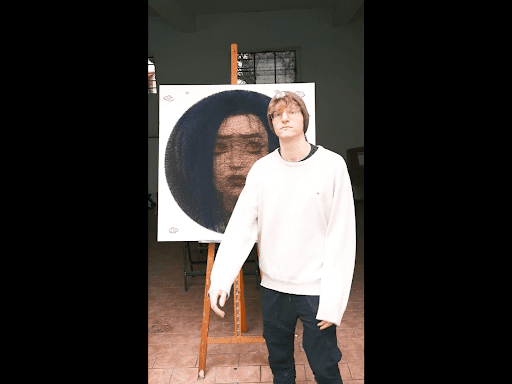 Thread_Art next to his artwork