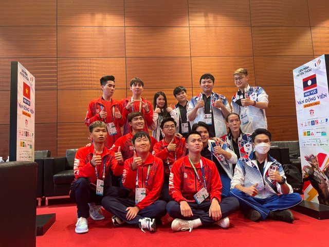 Vietnamese and Laotian players take a commemorative photo after the group stage ends