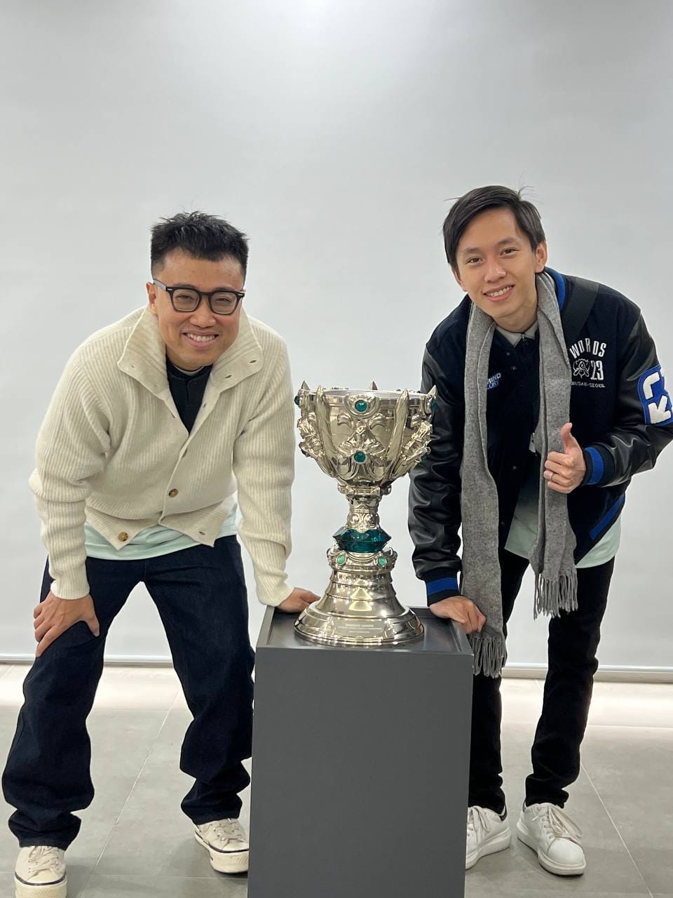 Commentator duo Hoàng Luân - Văn Tùng and the 2020 World Championship trophy of Damwon Gaming