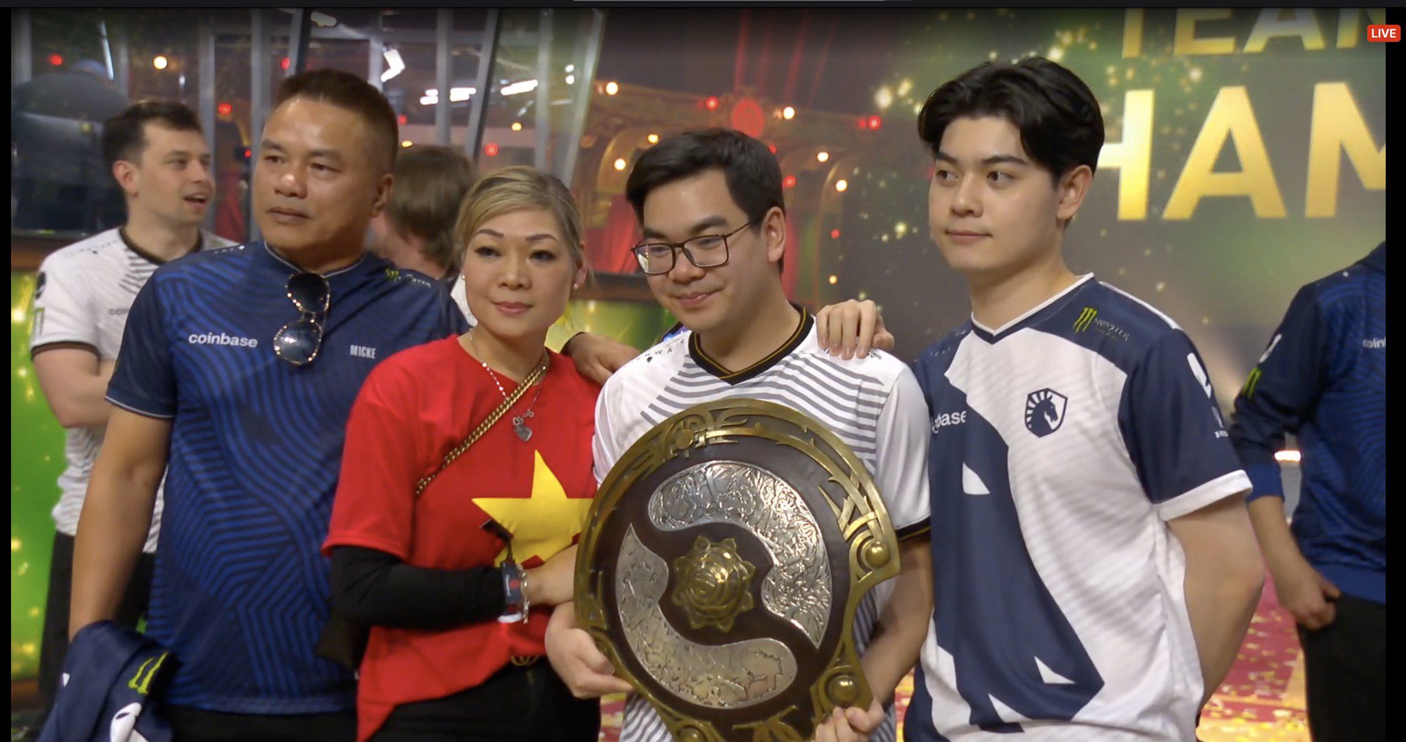 Image of the Vietnamese flag appearing at TI 2024 when miCKe's family (the one holding the TI shield) comes up to congratulate him